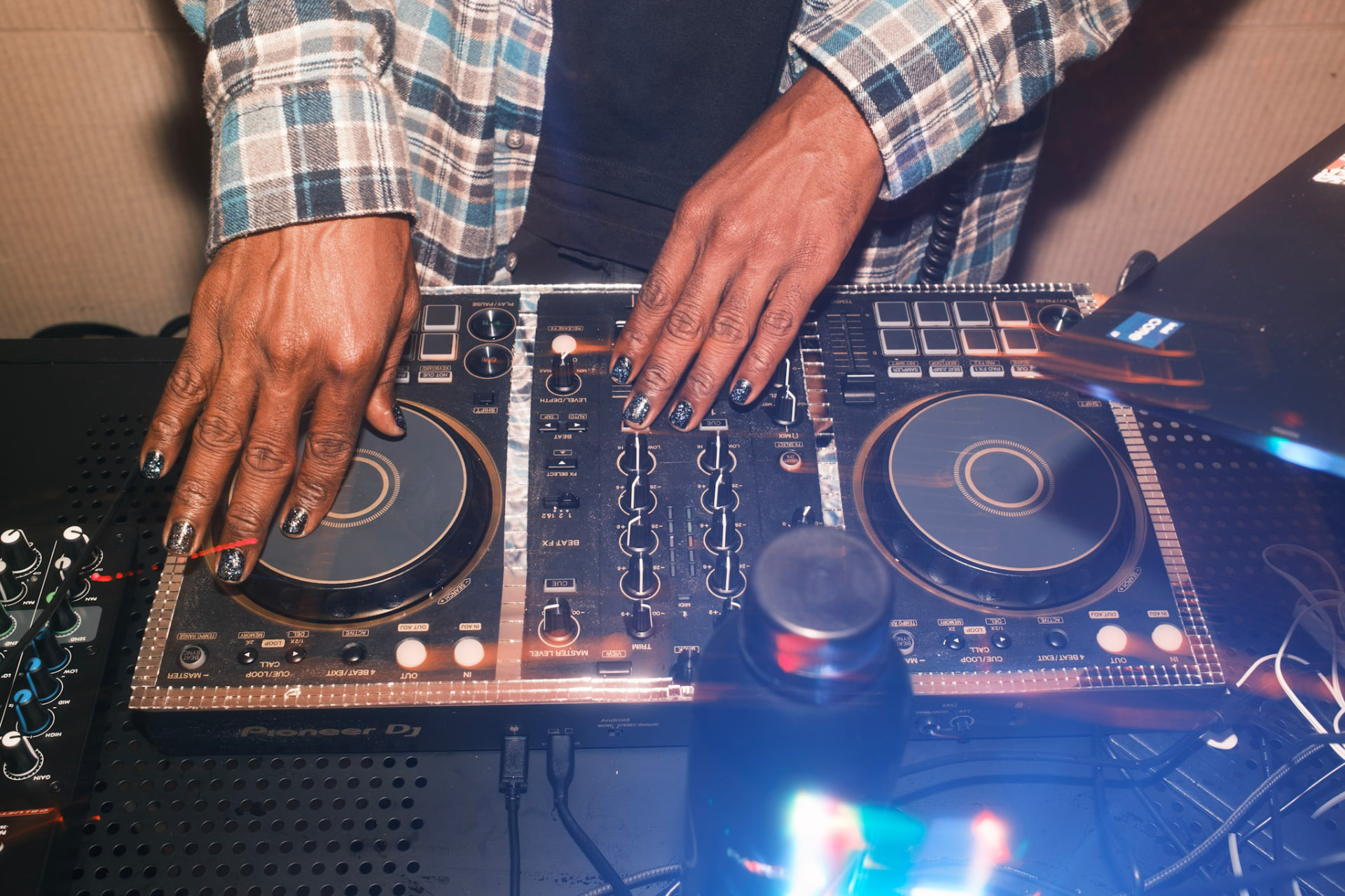 The SEVENth's hands on a DJ controller